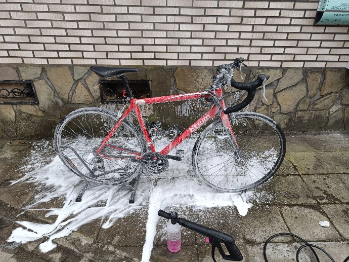 Photo d'un vélo en train d'être nettoyer par la station portable Mucoff qui permet de laver chez les client les vélos