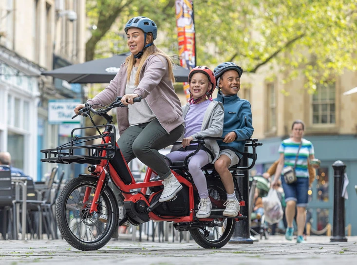 une maman avec ses deux enfants sur un tern quick haul long