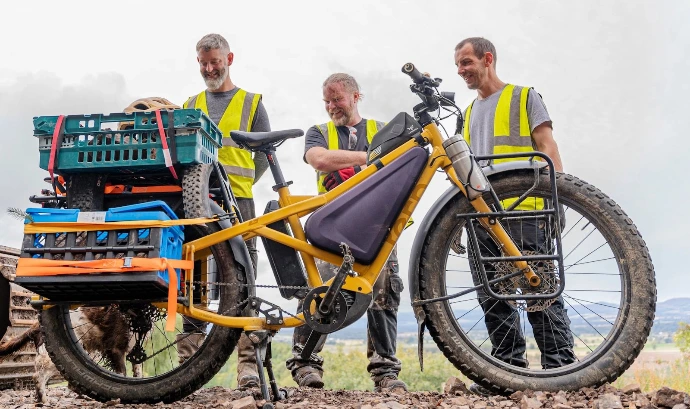 un Vélo tern orox avec des ouvriers et des caisses de matériel sur le vélo